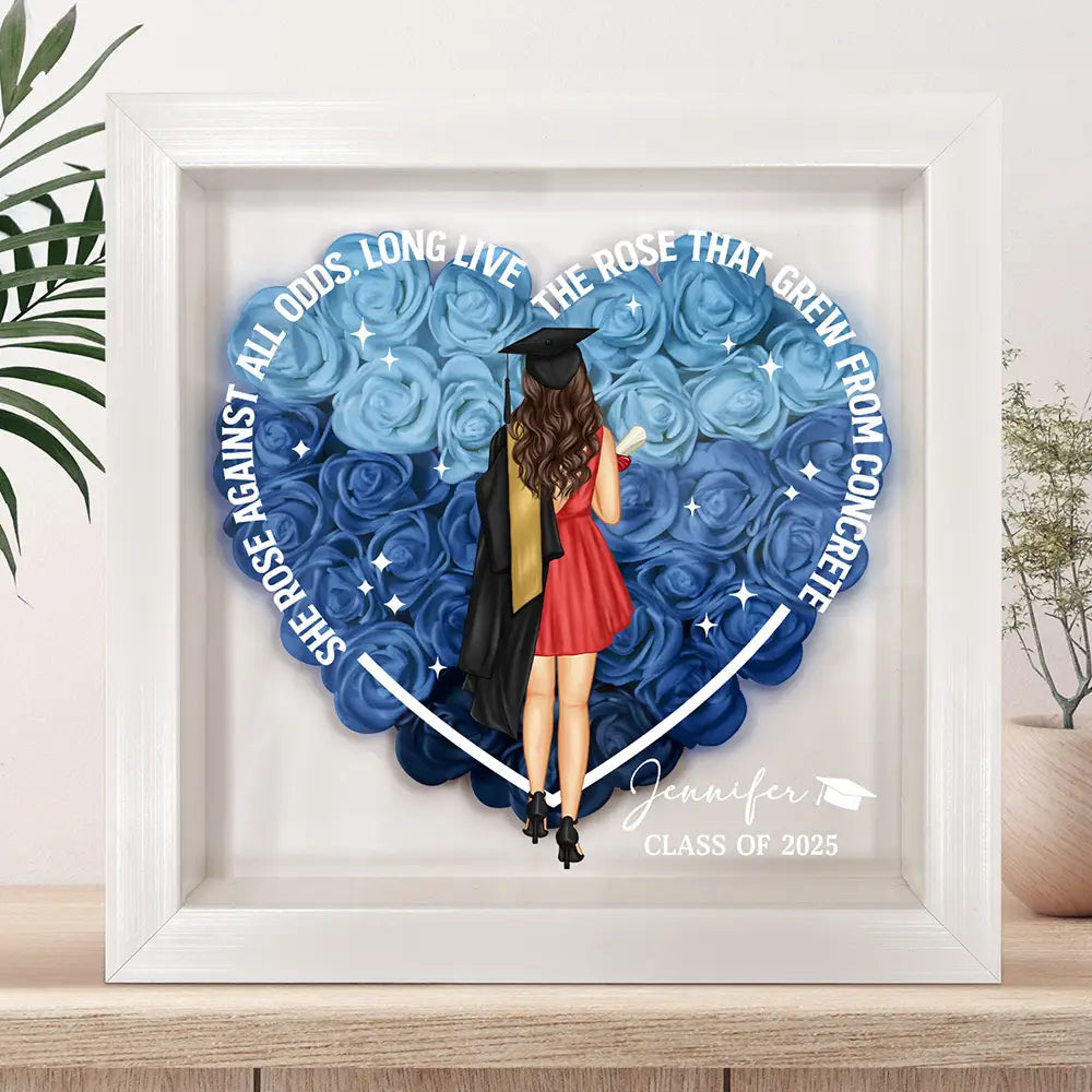 Personalized graduation flower shadow box with woman in cap and gown, blue flowers, and inspirational message